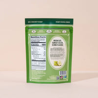Green snack package with nutrition label on a beige background
