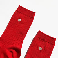 Red socks with heart-shaped charms on a white background