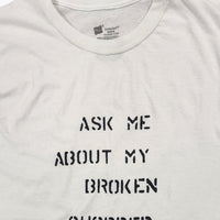 White t-shirt with text 'Ask me about my broken chopper' on a white background