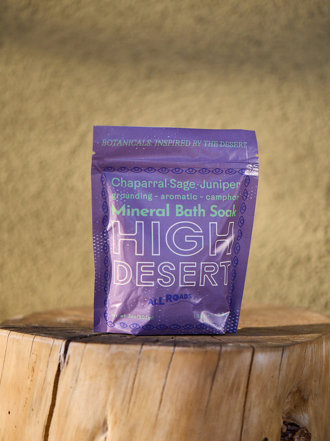 Purple package of High Desert Mineral Bath Soak on a wooden surface with a beige background