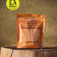 Palm Valley Gold Mineral Bath Soak package on a wooden surface with a blurred background