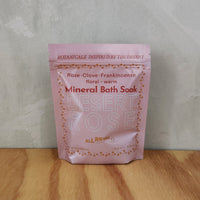 A pink pouch of mineral bath salts containing essential oils and scent of rose and clove.
