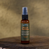 Hand sanitizer bottle labeled 'Desert Midnight' on a wooden surface with a brown background