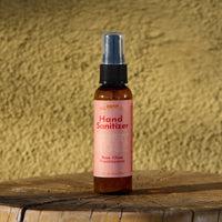 Hand sanitizer bottle on a wooden surface with a textured yellow wall background