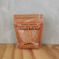 A yellow pouch of mineral bath salts containing citrus and vanilla essential oils.