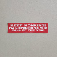 Red bumper sticker with text on a gray background