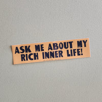 Bumper sticker with text 'Ask me about my rich inner life!' on a gray background