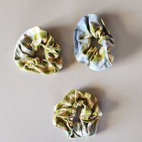 Three plaid scrunchies on a plain background