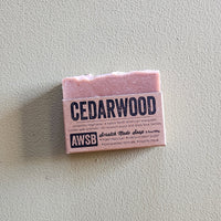Bar of soap labeled 'Cedarwood' on a light gray background