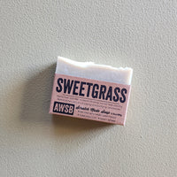 Bar of soap with 'Sweetgrass' label on a light gray background