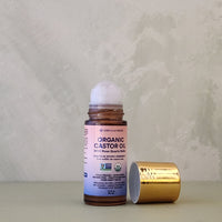 Organic castor oil bottle with gold cap on a textured surface