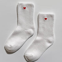 White socks with red hearts on a light gray background