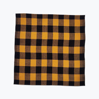 Large scale gingham plaid napkin in ochre yellow and black.