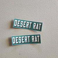 Two 'DESERT RAT' emblems on a gray background