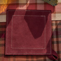 Purple leather potholder on a checkered fabric background