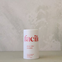 White cylindrical container with 'facile' branding on a textured surface