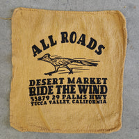 Beige burlap bag with black text and a logo on a gray concrete surface