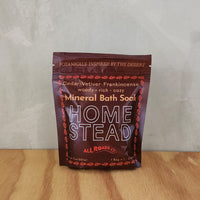 A burgundy pouch of bath salts scented with cedar, vetiver and frankincense essential oils.