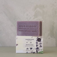 Bar of soap with packaging labeled 'Juniper Ridge' on a neutral background