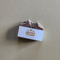 Bar of soap with a label on a beige background