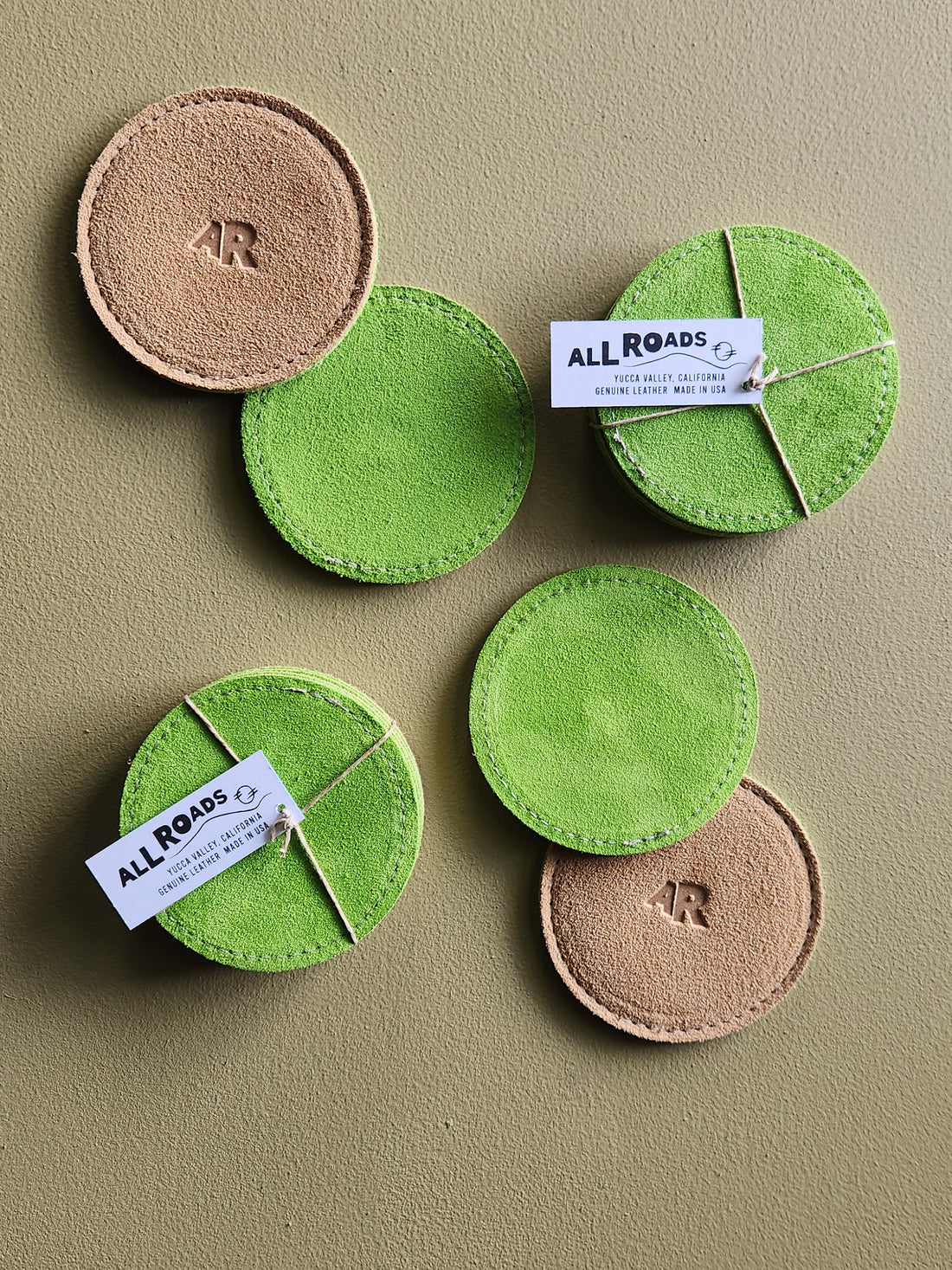 set of 4 suede coasters, one side lime green, the other side tan with an AR brand.