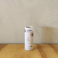 A vegan coconut cacao flavored lip balm in a cardboard tube.