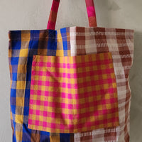 Colorful plaid tote bag on a plain background