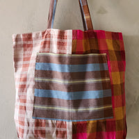 Plaid tote bag with multicolor pattern on a plain background