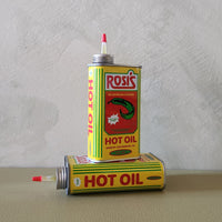 A metal can that says Rosi's Hot Oil on a green backgroun.