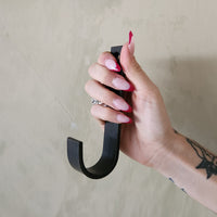An oversized black steel J hook