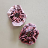 Two pink plaid scrunchies on a light gray background