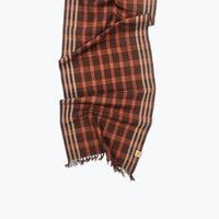 Brown and salmon checkered scarf with frayed edges on a white background