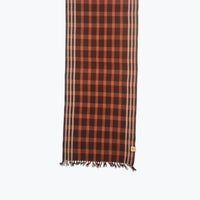 Plaid scarf with brown and salmon pattern on a white background