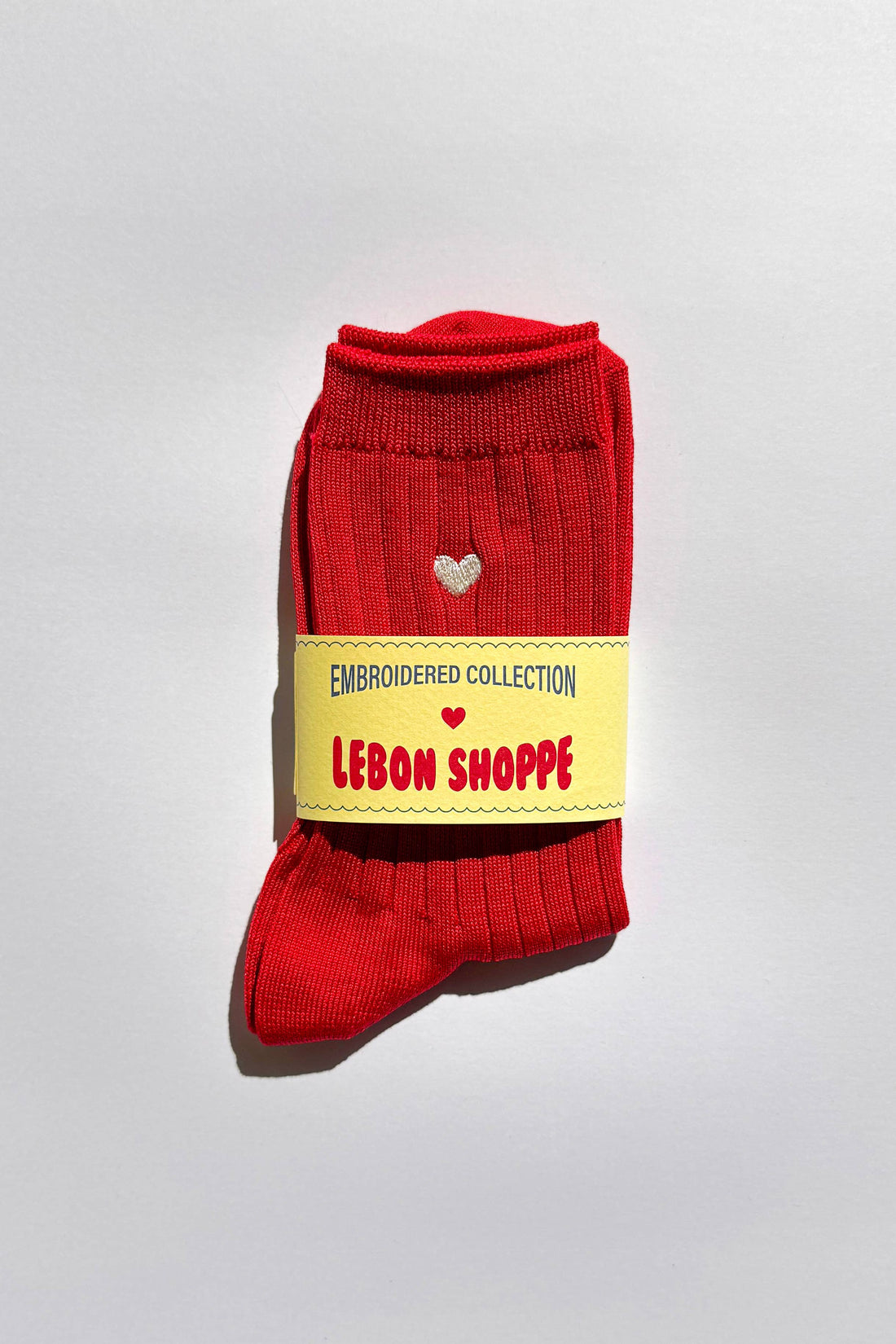 Red sock with a yellow label on a light gray background