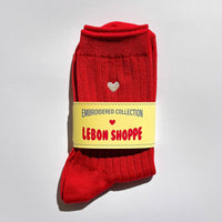 Red sock with a yellow label on a light gray background