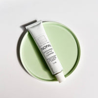 Skincare tube labeled 'Nopal' on a light green circular disc with a white background