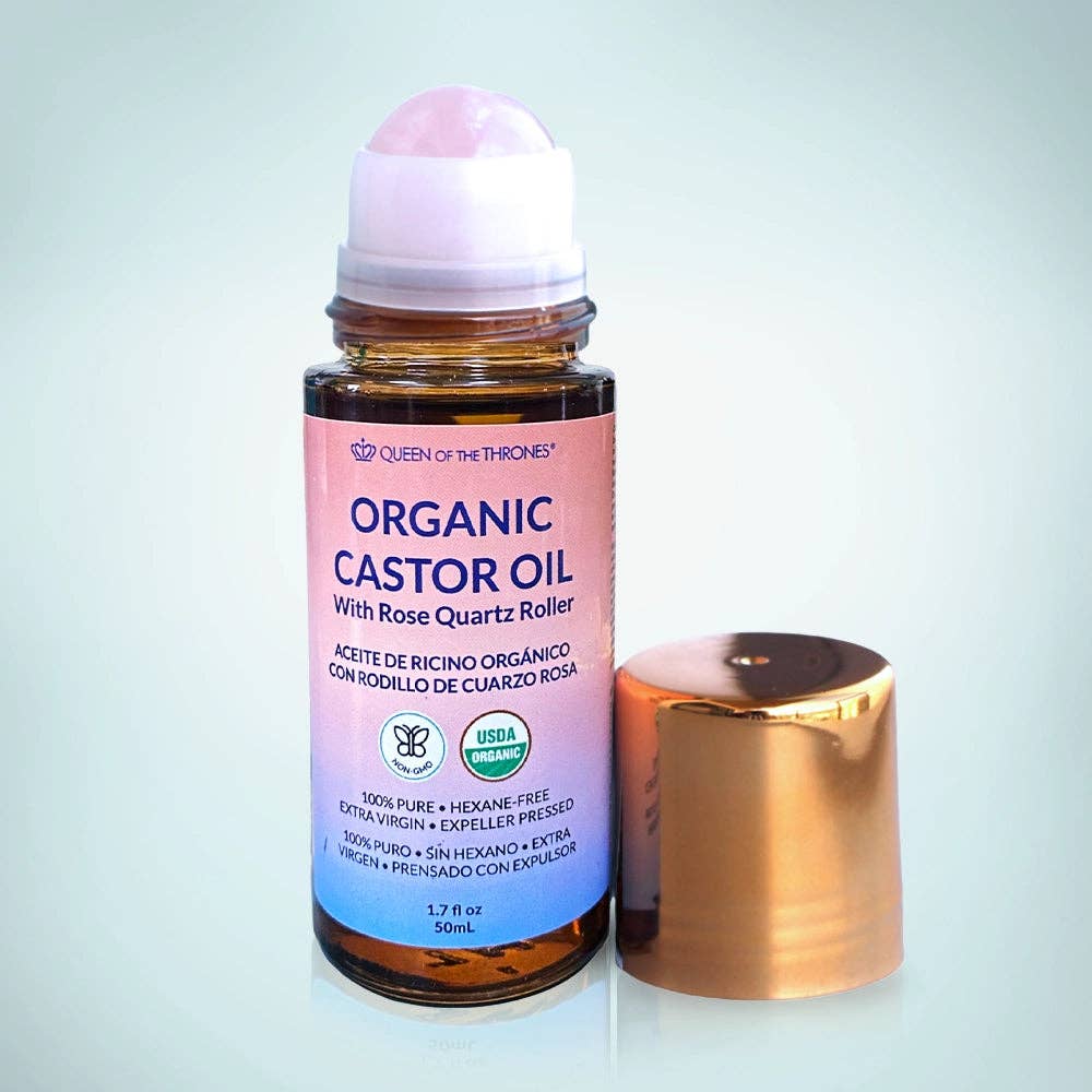 Organic castor oil bottle with rose quartz roller on a light gray background