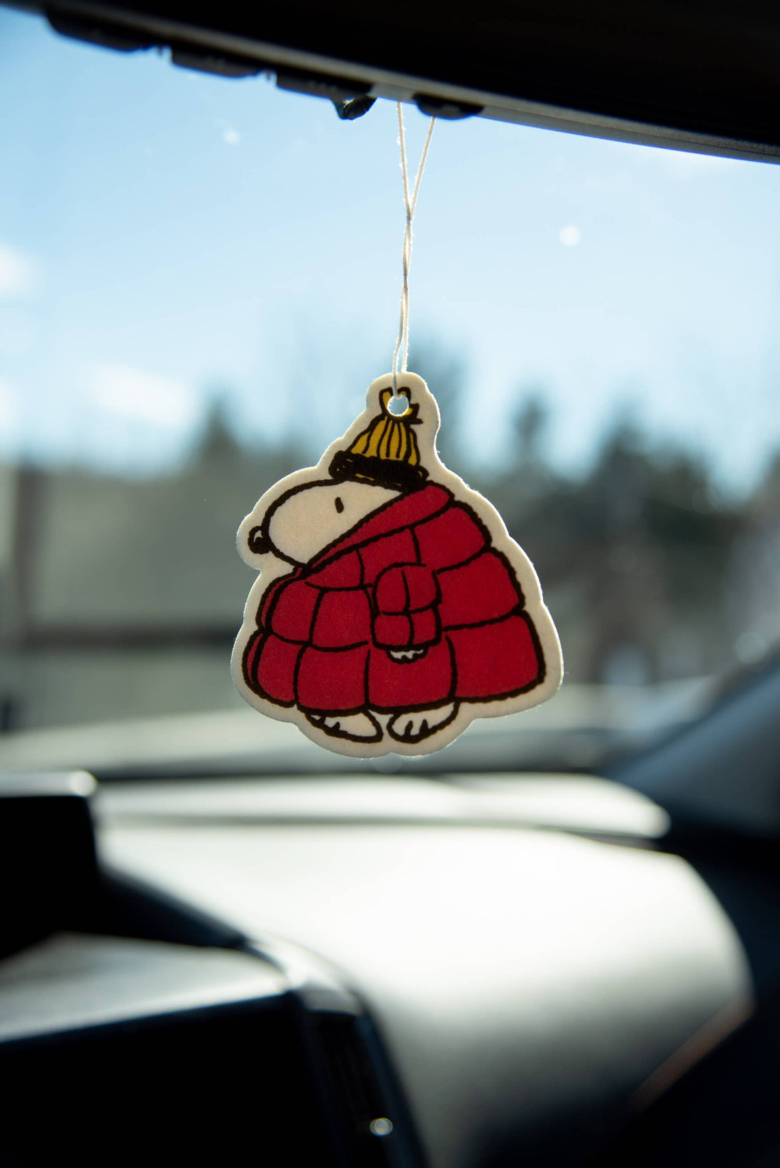 Car air freshener shaped like a cartoon character in a red coat hanging from a car&