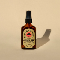 Bottle of Thundercloud Cerebone Spray on a beige background