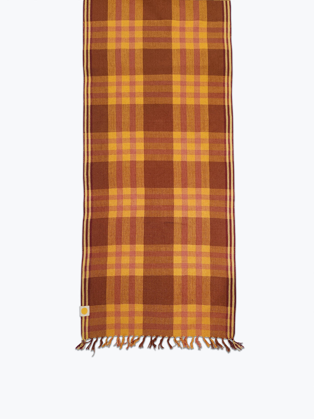 Brown and pink plaid table runner with fringed edges. 