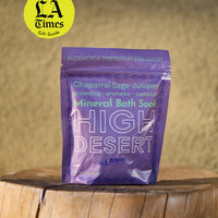 Purple package of High Desert Mineral Bath Soak on a wooden surface with a blurred background