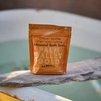 Palm Valley Gold mineral bath soak package on a bathtub rim