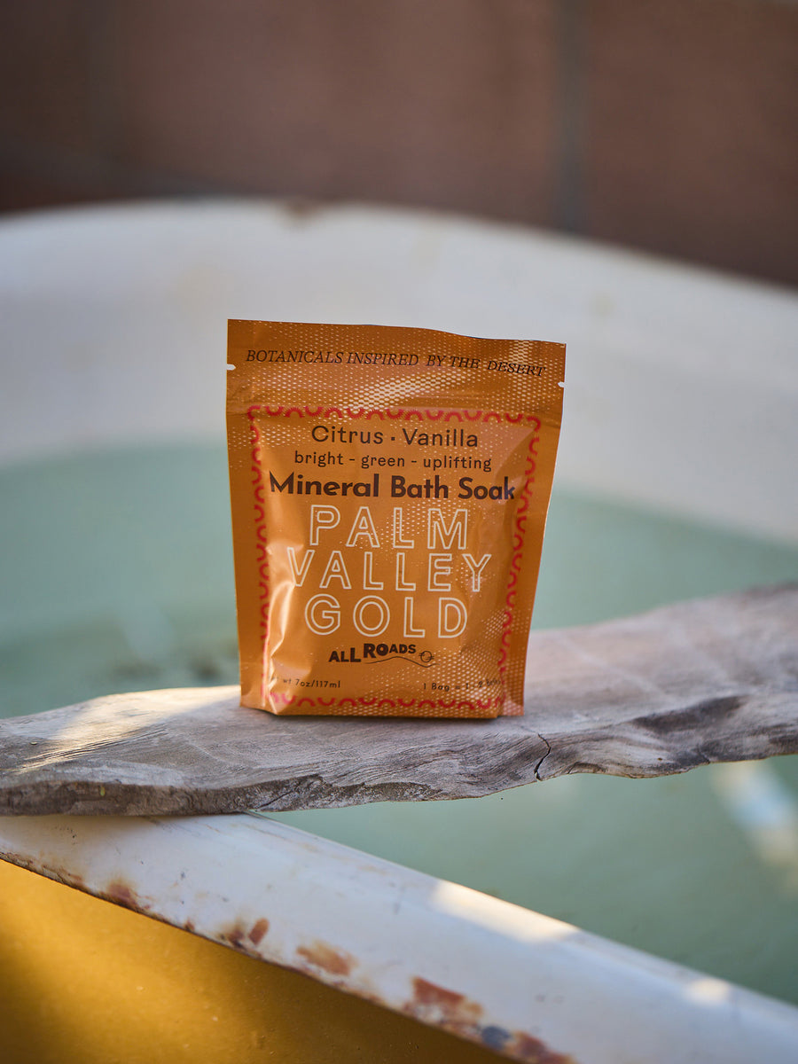 Palm Valley Gold mineral bath soak package on a bathtub rim