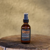 Brown spray bottle labeled 'Desert Midnight' on a wooden surface with a beige background