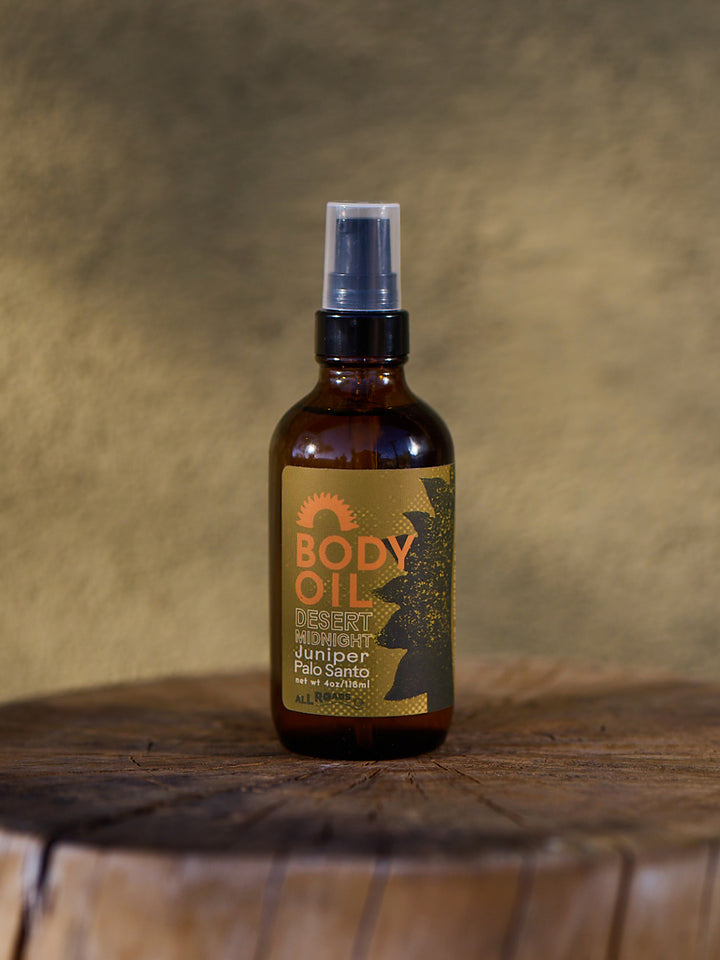 Body oil bottle with a label on a wooden surface and textured background