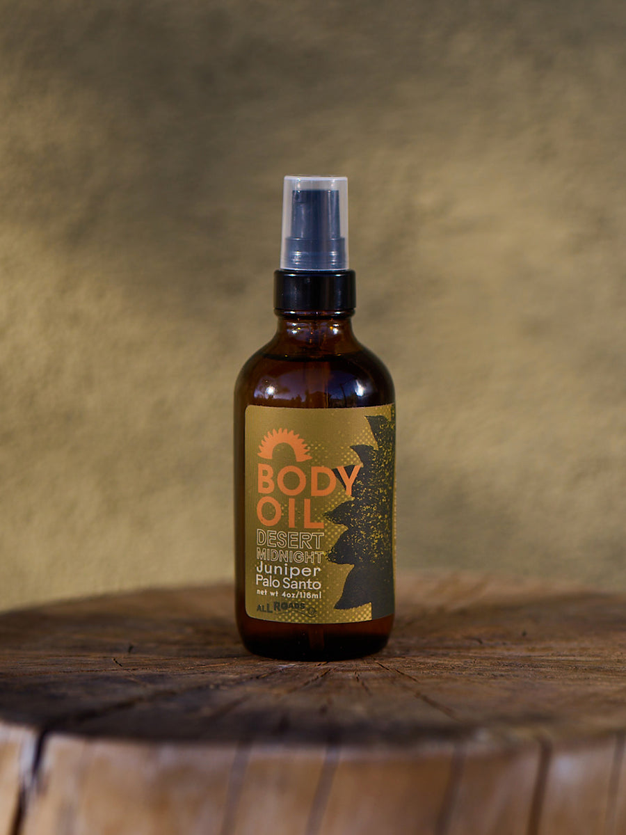 Body oil bottle with a label on a wooden surface and textured background