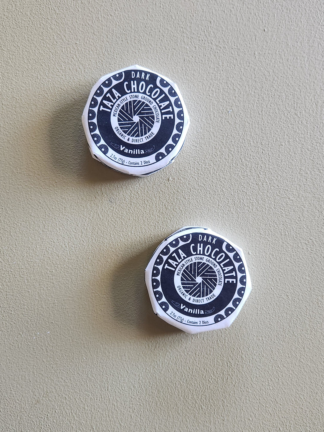 Two containers of Taza Chocolate Vanilla on a beige background