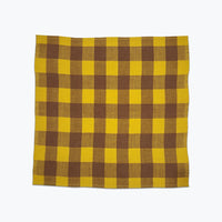 Large scale gingham plaid napkin of bright yellow and tan. 