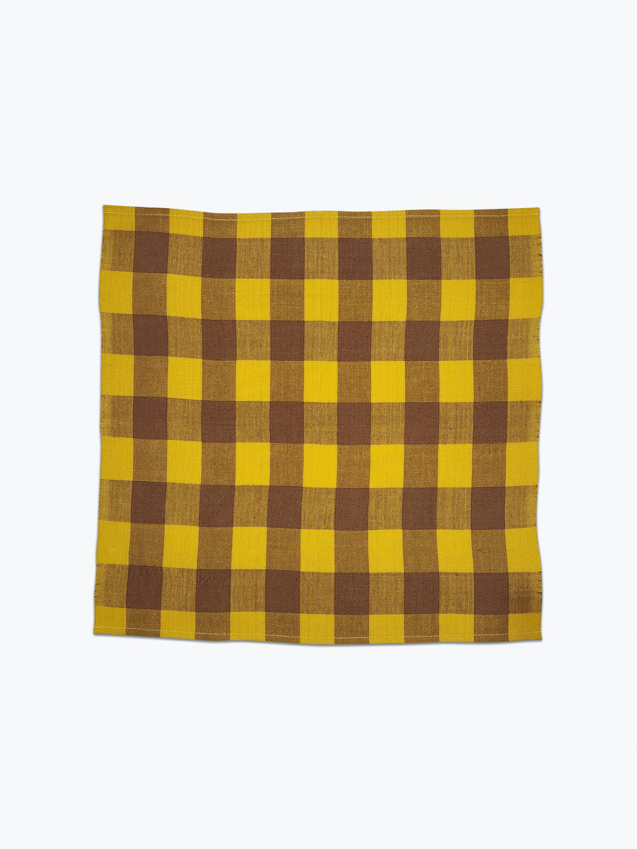 Large scale gingham plaid napkin of bright yellow and tan. 