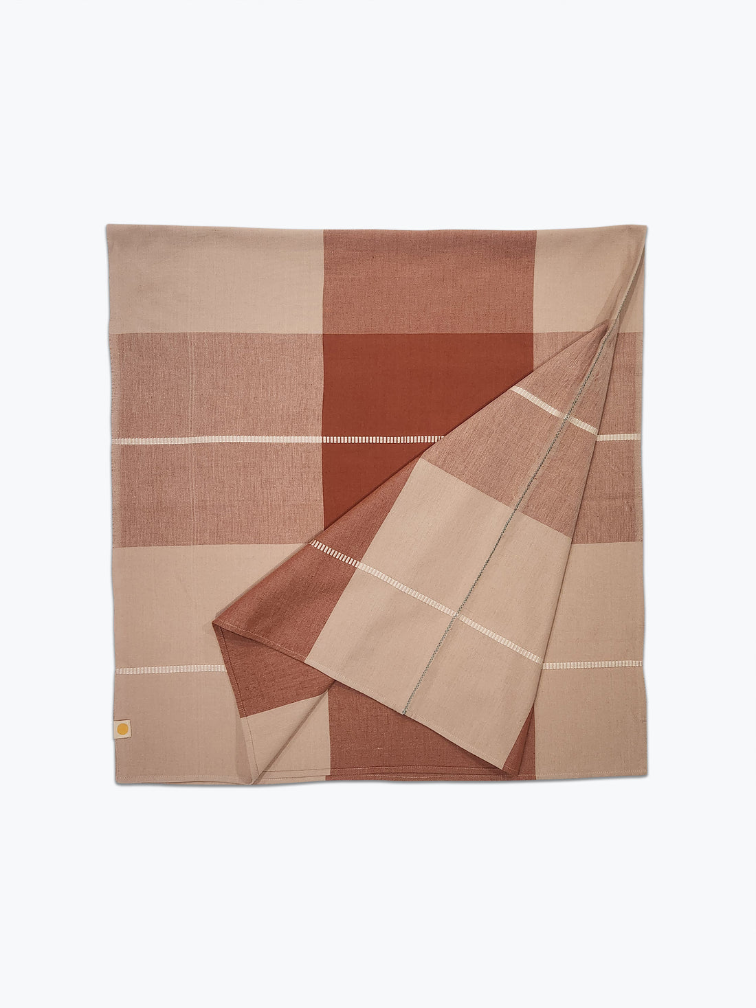 Folded checkered tablecloth with brown and beige colors on a white background